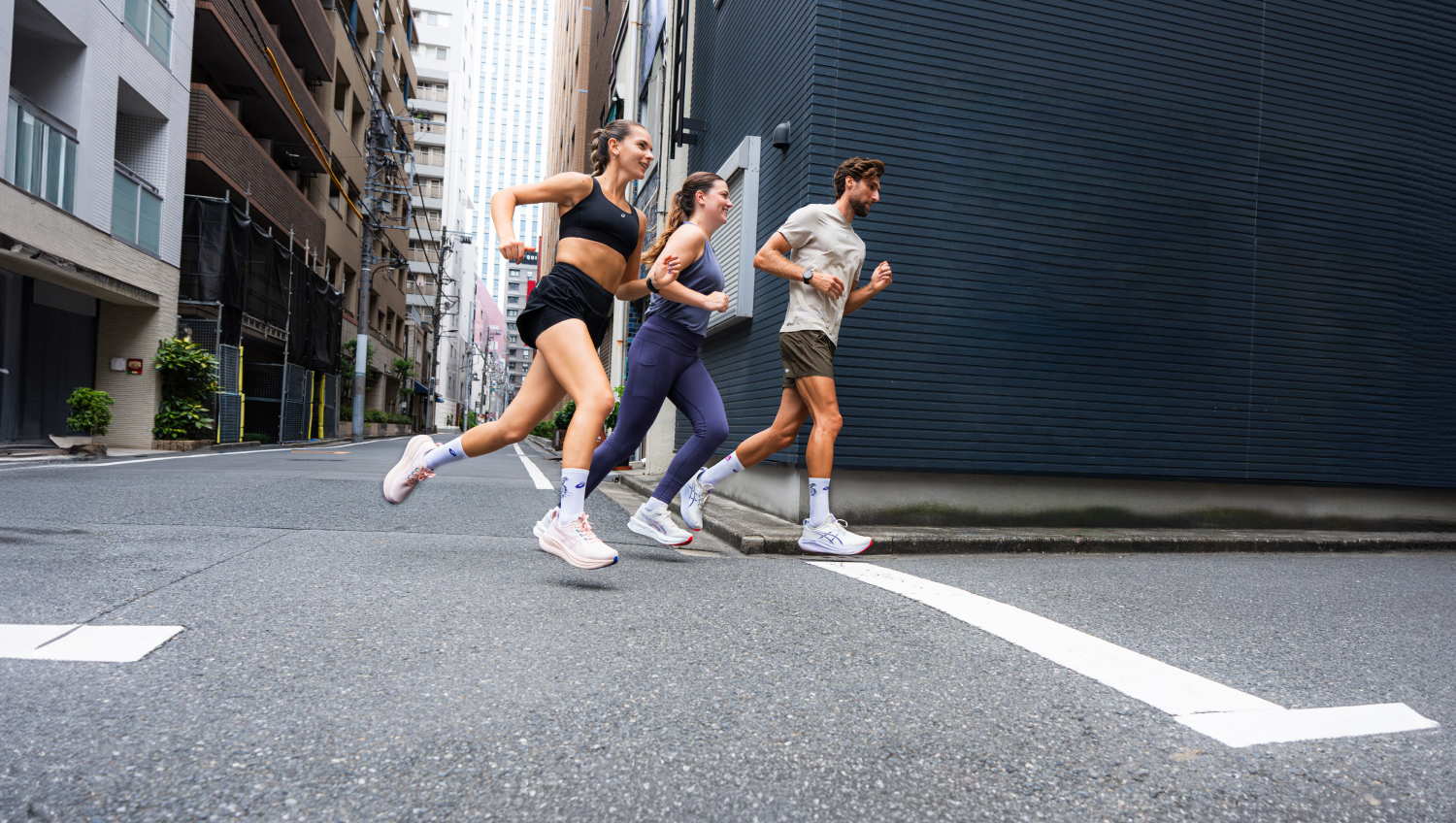 Two women and a man jogging in the city